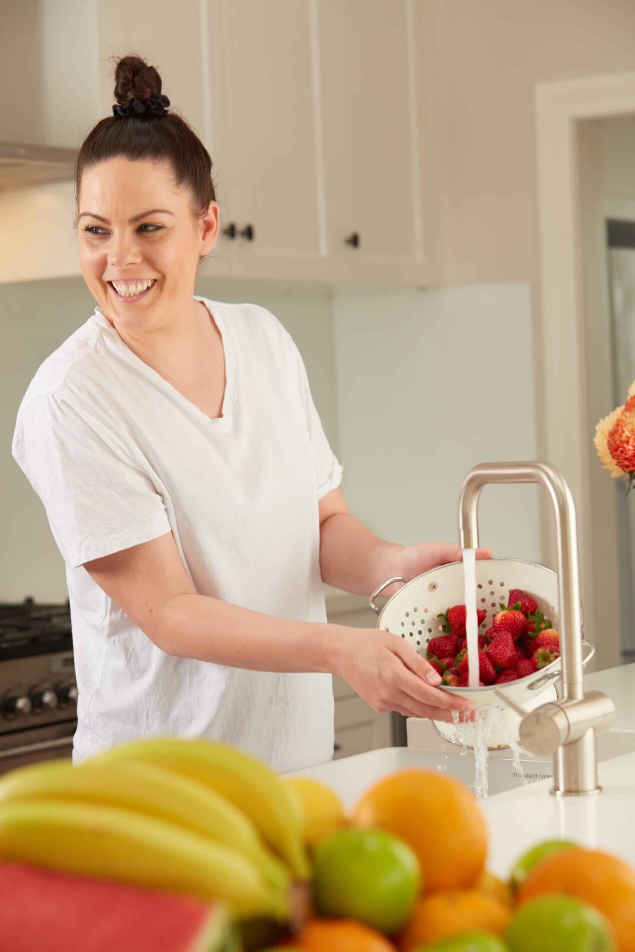 W2W Lady washing fruit with chilled filtered water tap
