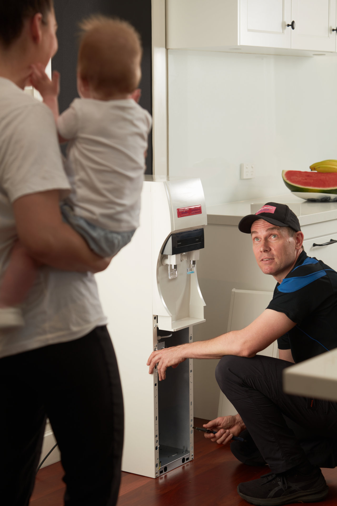 W2W-Water-Filtration-Technician-Servicing-Water-Cooler-in-Customers-Kitche